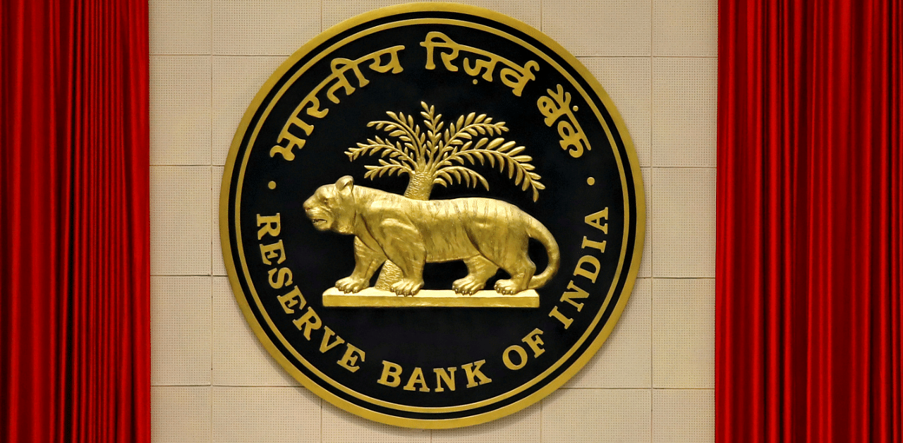 A worker walks past the logo of Reserve Bank of India inside its office in New Delhi. Credits: Reuters Photo