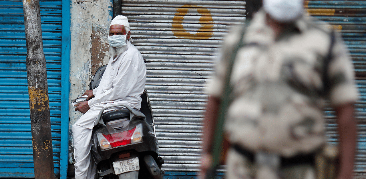 A Muslim man wearing face mask is seen outside the Jama Masjid (Grand Mosque) after Eid al-Adha prayers, next to a paramilitary soldier, during the outbreak of the coronavirus. Credits: Reuters Photo