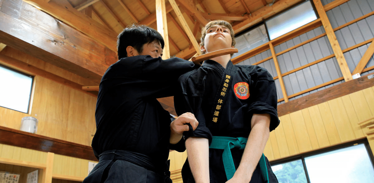 Genichi Mitsuhashi, 45, the first person to hold a degree from Mie University's graduate course on ninja studies, teaches martial arts to a guest in a training hall next to his home in Iga, Mie Prefecture, central Japan. Credit: Reuters Photo 