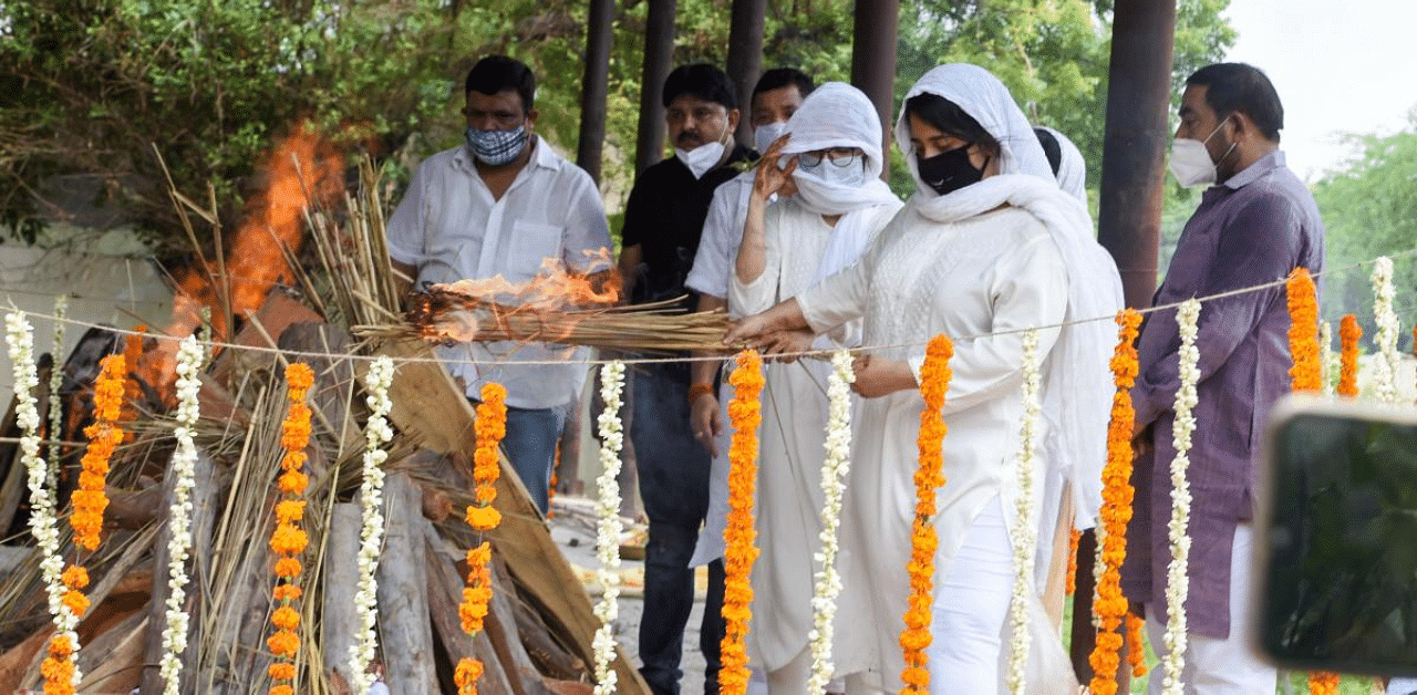Daughters Drishti and Disha consign flames to the mortal remains of Rajya Sabha member Amar Singh, at a crematorium at Chhatarpur in New Delhi. Credit: PTI Photo