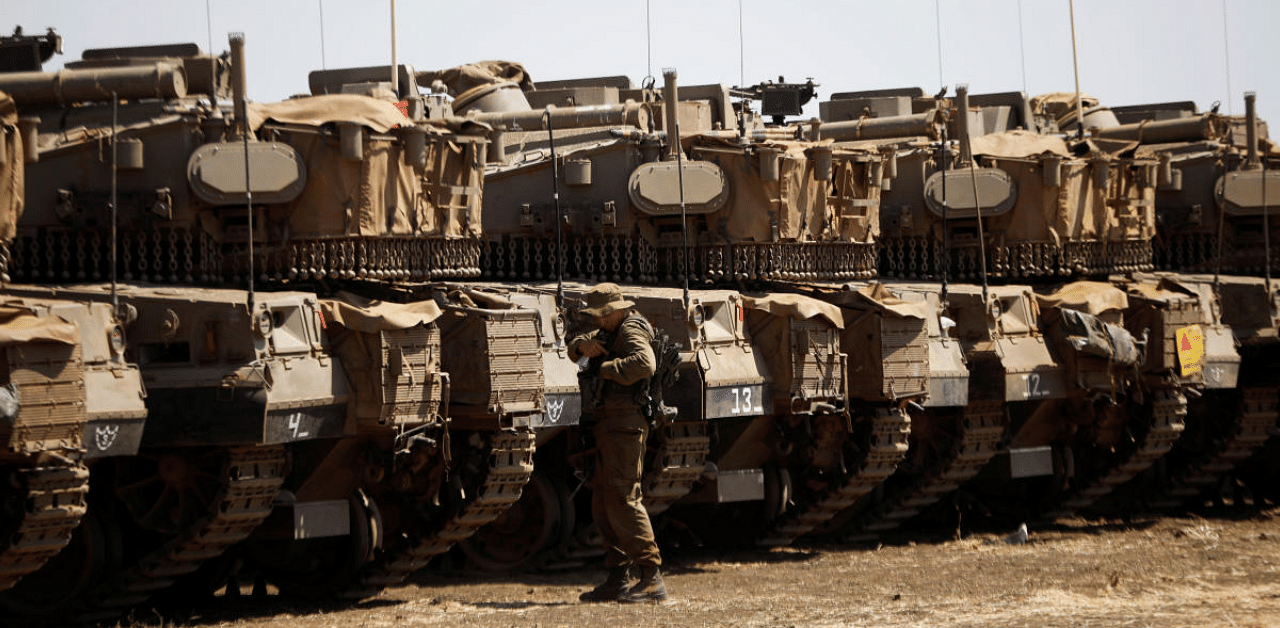 An Israeli soldier stands near tanks in the Israeli-controlled Golan Heights near the Israel-Syria frontier. Credit: Reuters Photo