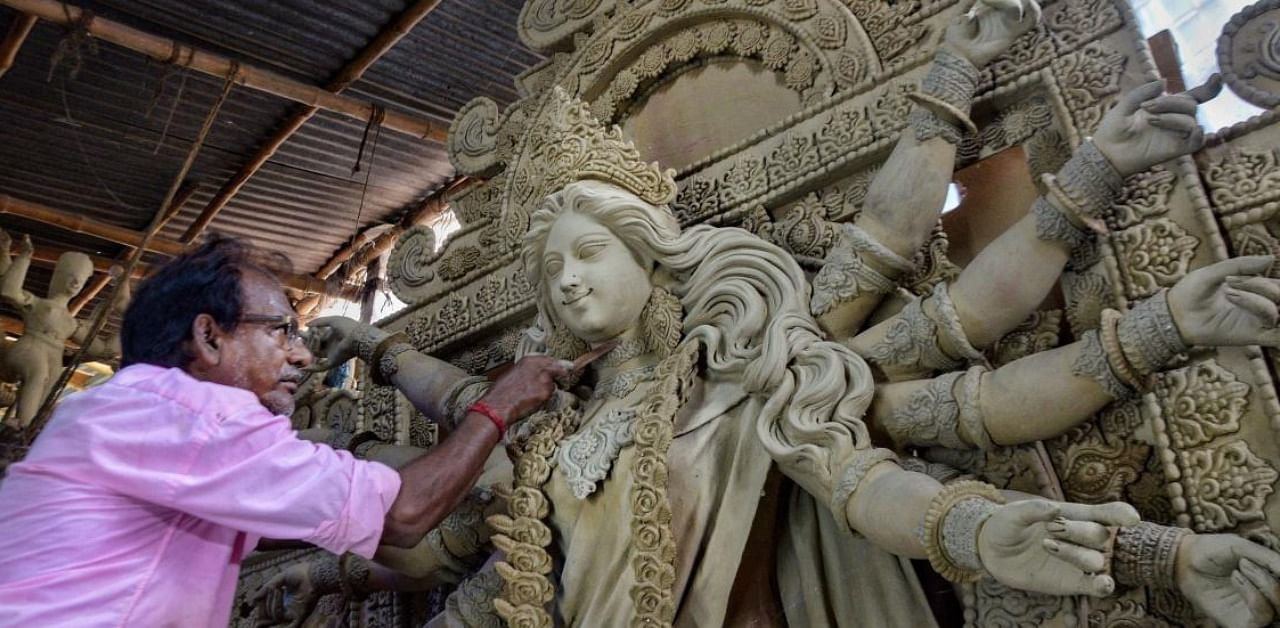 An artist makes a clay idol of Goddess Durga for puja festivities, at Krishna Nagar in Nadia District. Credit: AFP