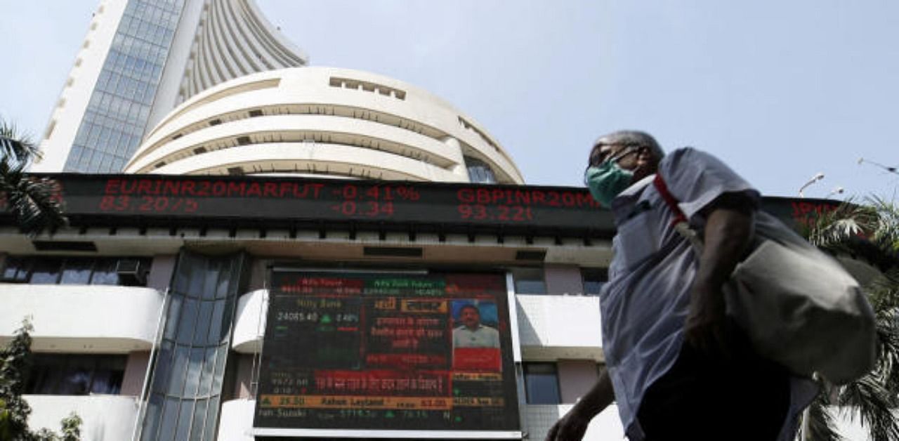 A man wearing a protective mask walks past the Bombay Stock Exchange (BSE) building . Credit: Reuters Photo