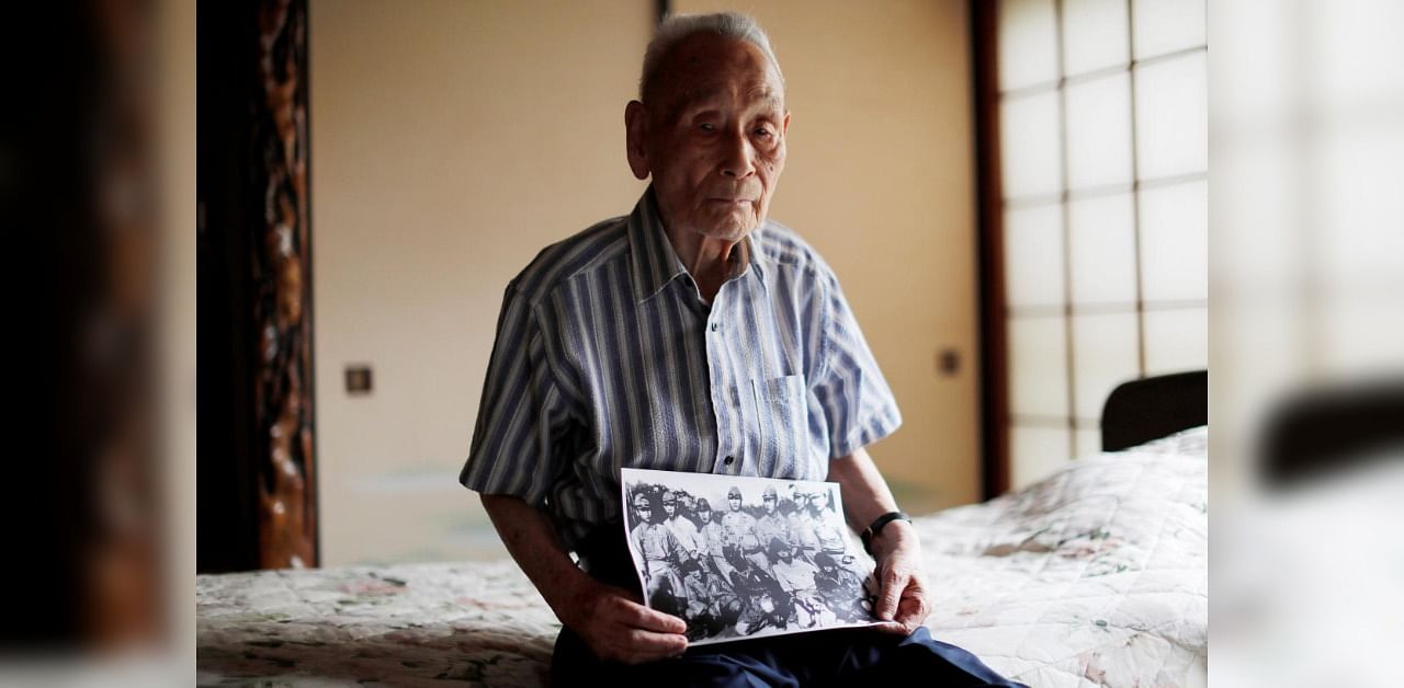 Lee Hak-rae, the last surviving Korean war criminal during World War II, holds a copy of photo that was taken at a POW camp run by the Japanese Imperial Army in Thailand in 1942, during an interview with Reuters at his home, in Tokyo, Japan June 25, 2020. Picture taken June 25, 2020. Credit: REUTERS