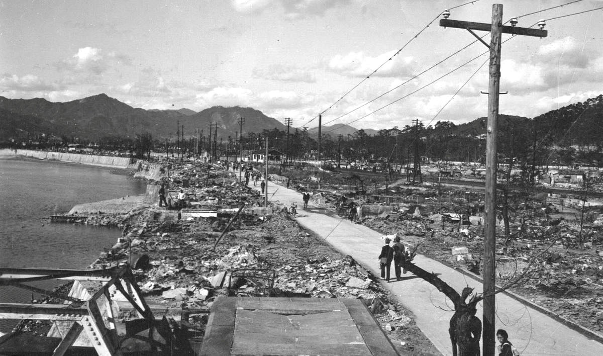 People walk along a road cleared of debris caused by the atomic bomb in Hiroshima, Japan in an undated photograph. War Department/U.S. National Archives/Handout via Reuters