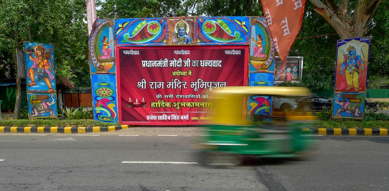 An autorickshaw rides past a banner showcasing Shri Ram Mandir Bhoomi Pujan event. Credit: PTI Photo