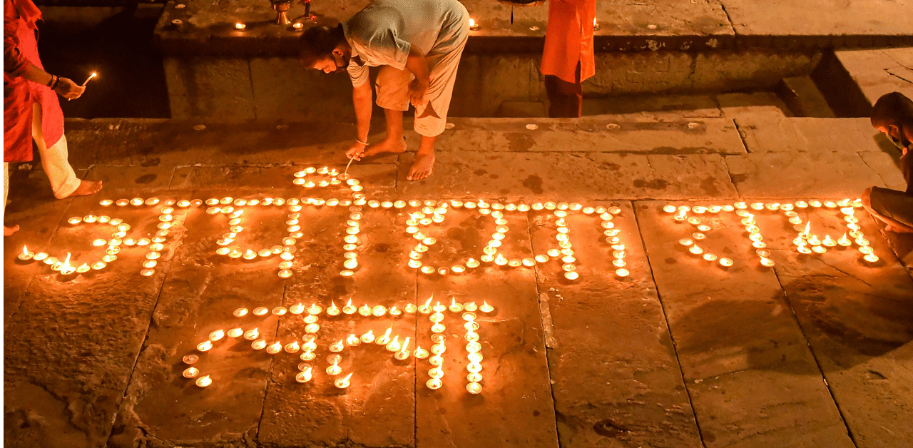 Devotees light earthern lamps during Ganga 'aarti' at Dashashmedh Ghat, ahead of the foundation laying ceremony of Ram Temple in Ayodhya, in Varanasi. Credit: PTI Photo