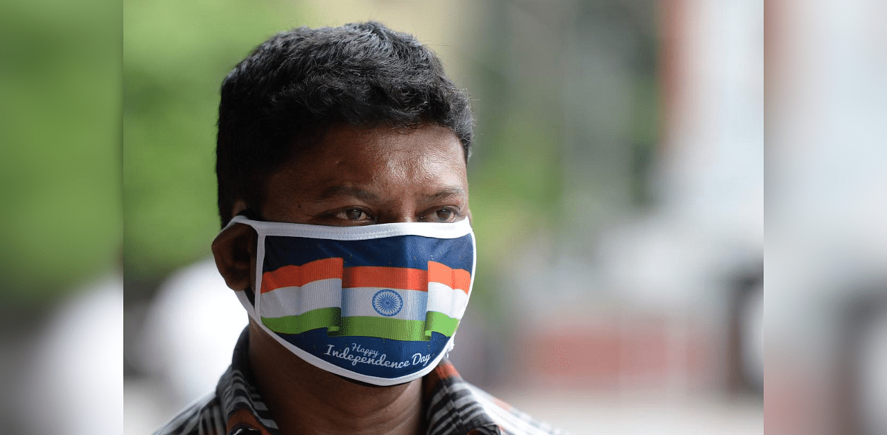 A vendor wearing a facemask with printed the National flag to attract customers for the upcoming Indian Independence Day sells facemasks on a street, in Hyderabad on August 4, 2020. Credit: AFP Photo