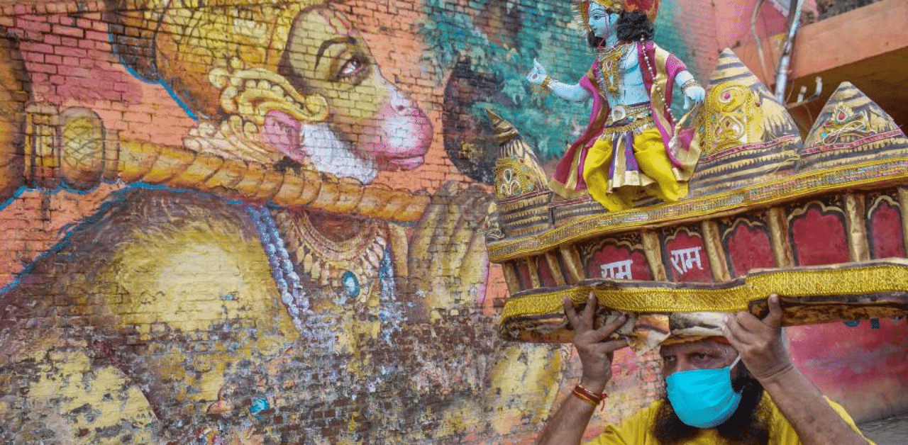  A worker carries a model of Ram Mandir on his head on the eve of the foundation stone laying ceremony of the temple in Ayodhya, in Prayagraj, Tuesday, Aug 4, 2020. Credit: PTI Photo