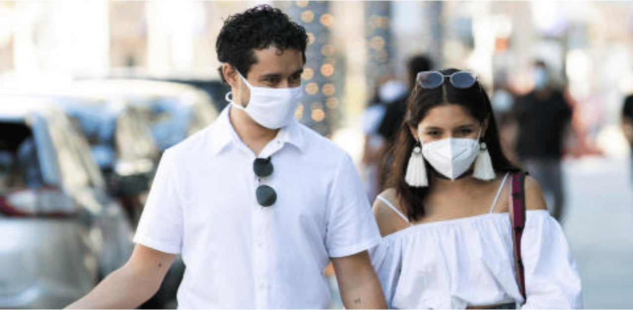 A couple wearing face masks walks during the outbreak of the coronavirus disease, in Beverly Hills, California, US. Credit: Reuters Photo