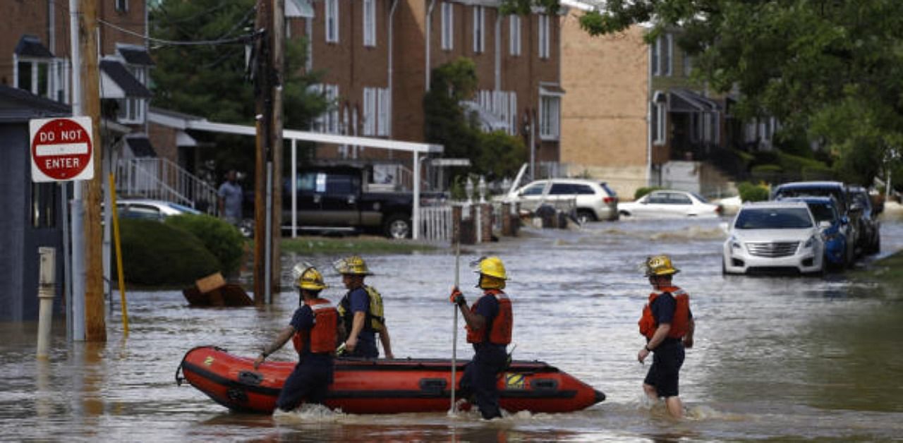 Philadelphia firefighters walk through a flooded neighborhood after Tropical Storm Isaias moved through. Credit: AP