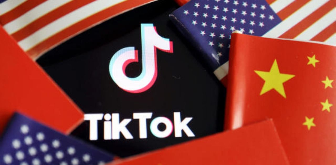 Chinese and US flags are seen near a TikTok logo. Credit: Reuters