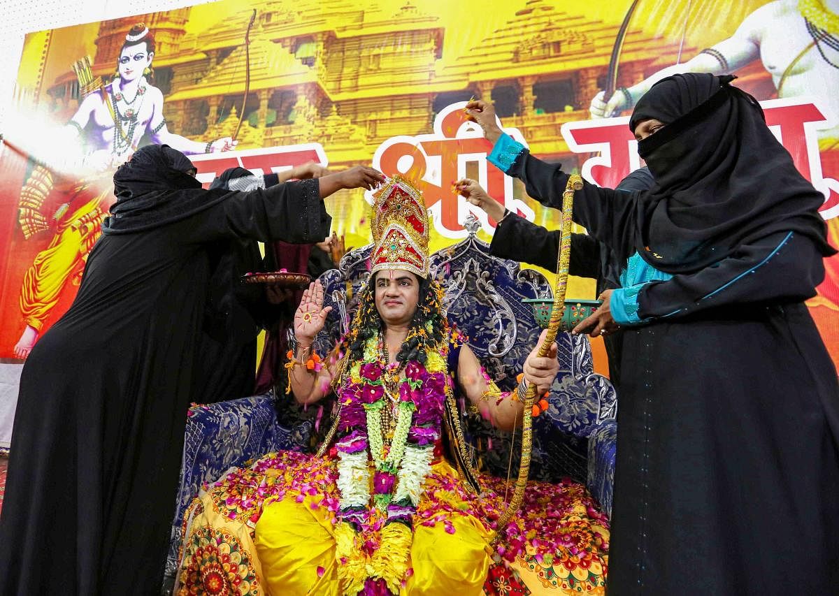 Muslim women shower flower petals on an artist dressed as Lord Ram, to celebrate the groundbreaking ceremony of the Ram Temple in Ayodhya, organised by Yuva Sanskritik Manch in Bhopal, Wednesday, Aug. 5, 2020. Credit: PTI Photo