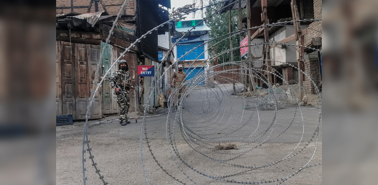  Security personnel stand guard on a street during the restrictions imposed on the first anniversary of the special status of Jammu and Kashmir. Credit: PTI