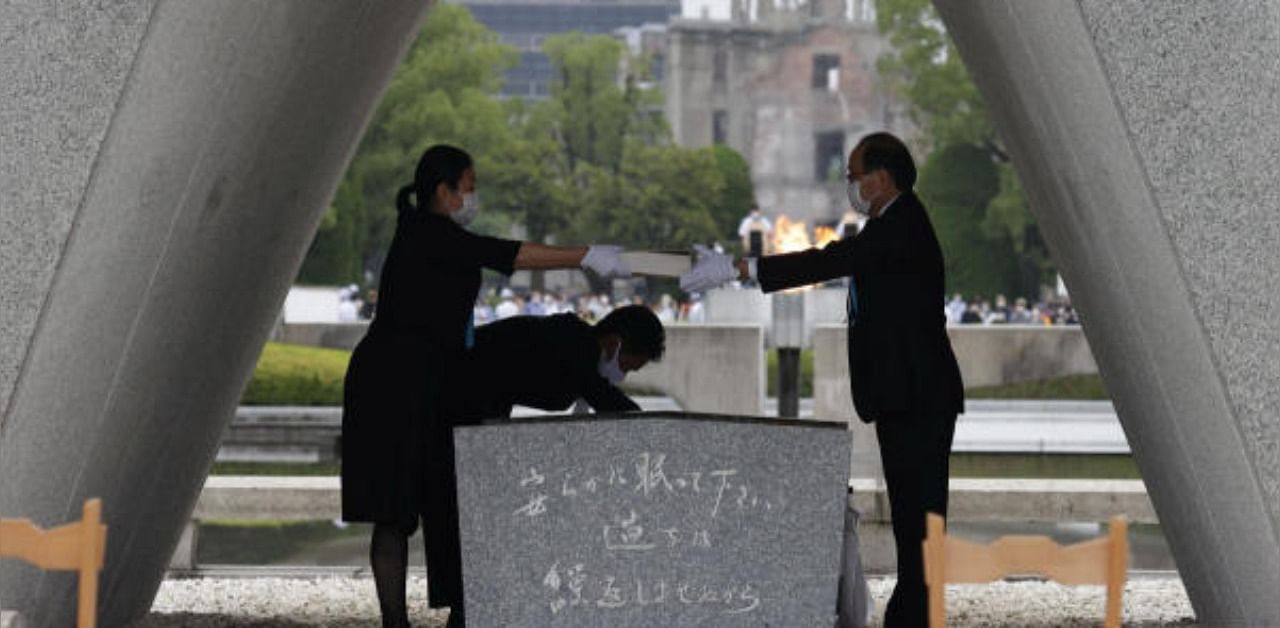 The name list of war dead is given to Hiroshima City mayor Kazumi Matsui from a representative of bereaved families of the 1945 atomic bombing victims. Credit: Reuters