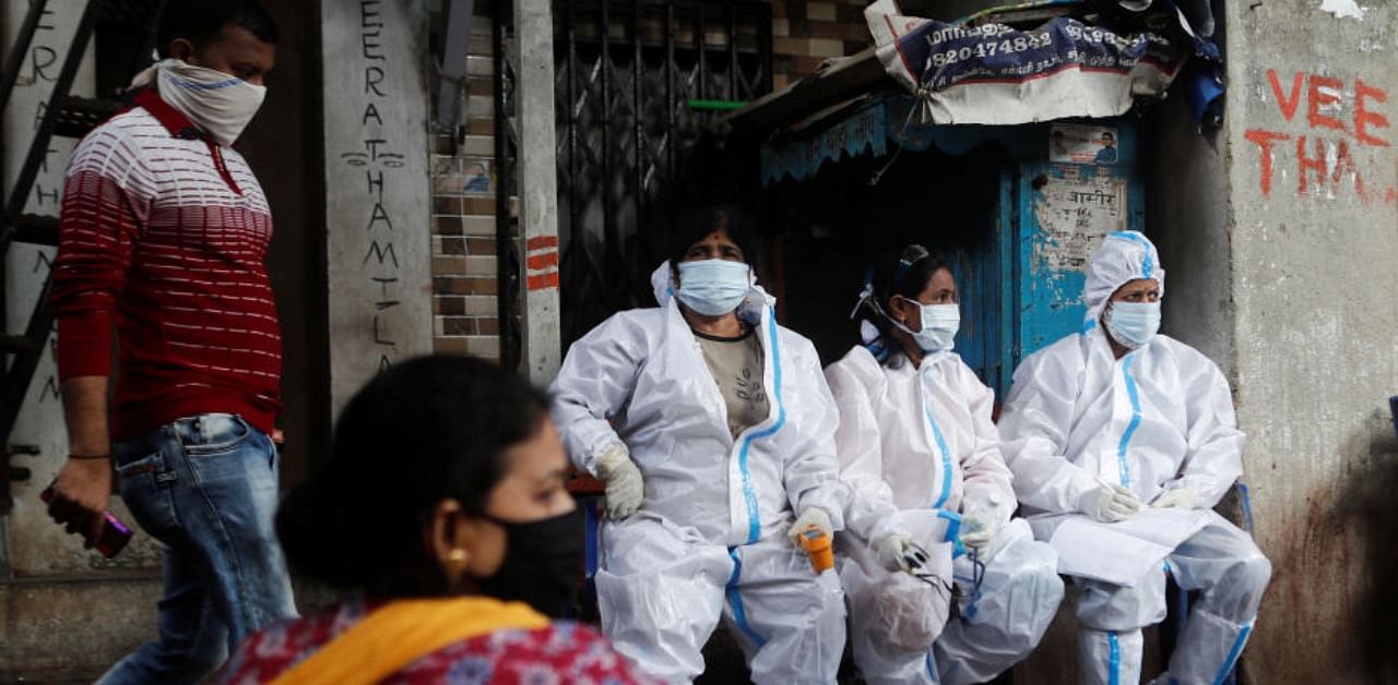 Health workers in personal protective equipment rest during a check up campaign for the coronavirus disease (COVID-19) at a slum area in Mumbai, India, August 3, 2020. (Reuters)