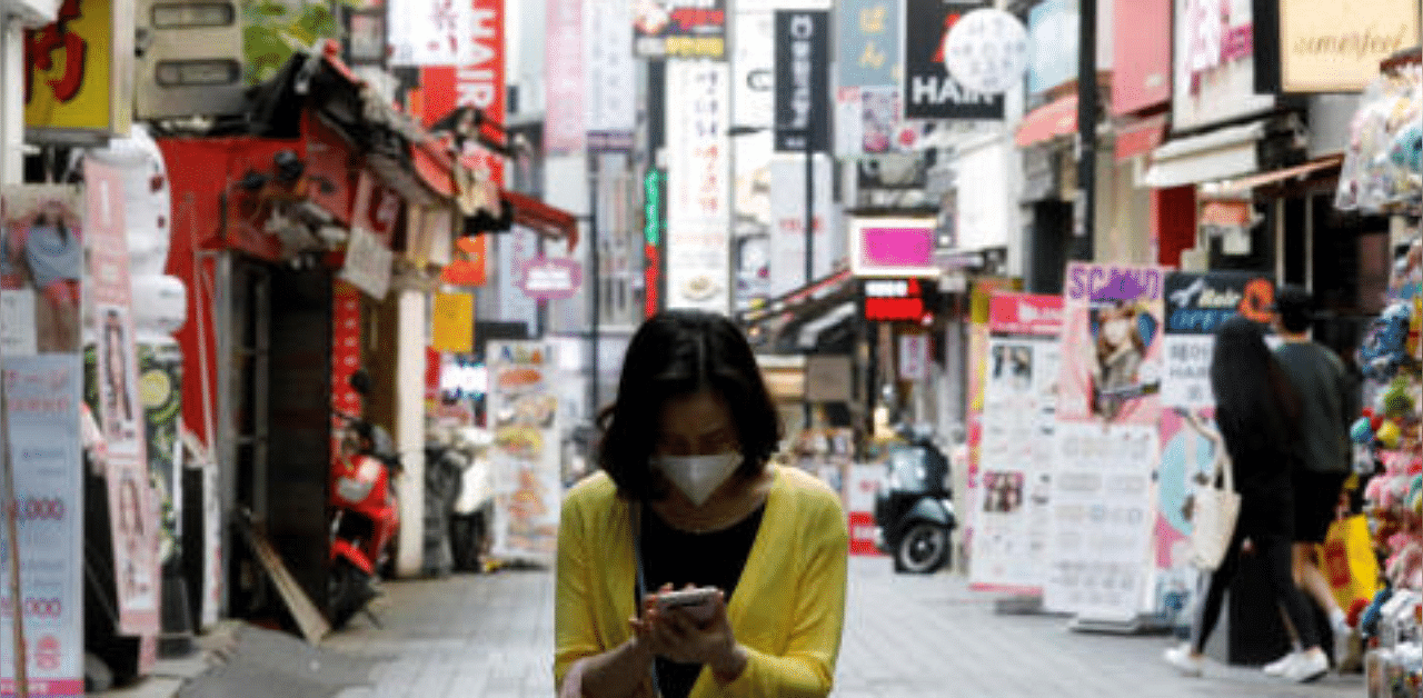 A woman wearing a mask looks at her mobile phone amid social distancing measures to avoid the spread of the novel coronavirus, in in Seoul, South Korea. Credit: Reuters Photo