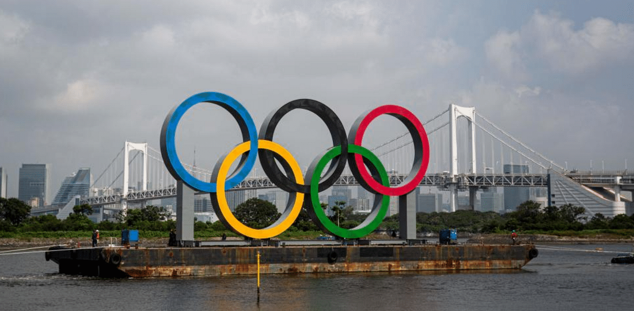 A large size Olympic rings symbol is seen in front of Rainbow Bridge at Tokyo Waterfront in the waters of Odaiba Marine Park. Credit: AFP