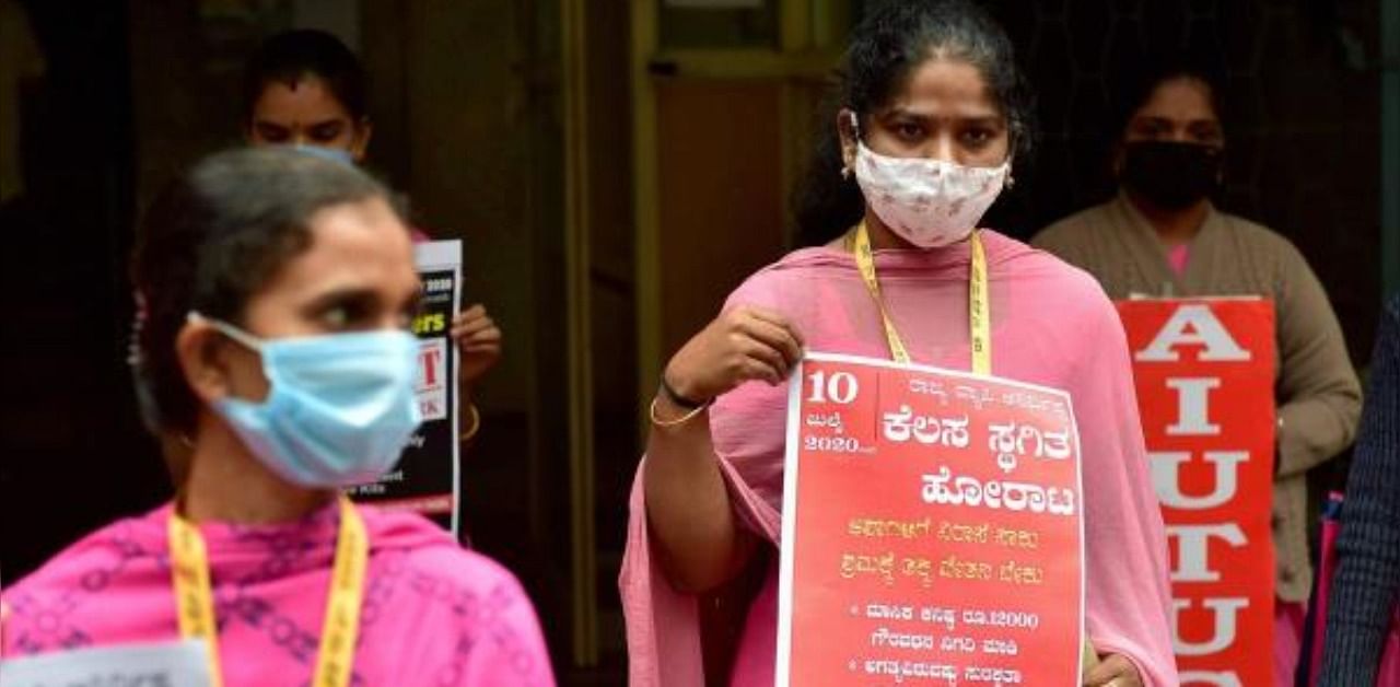Accredited Social Health Activists (ASHA) hold placards during a protest demanding for hike in wages and the safety kits to fight the Covid-19, in Bengaluru. Credit: PTI Photo