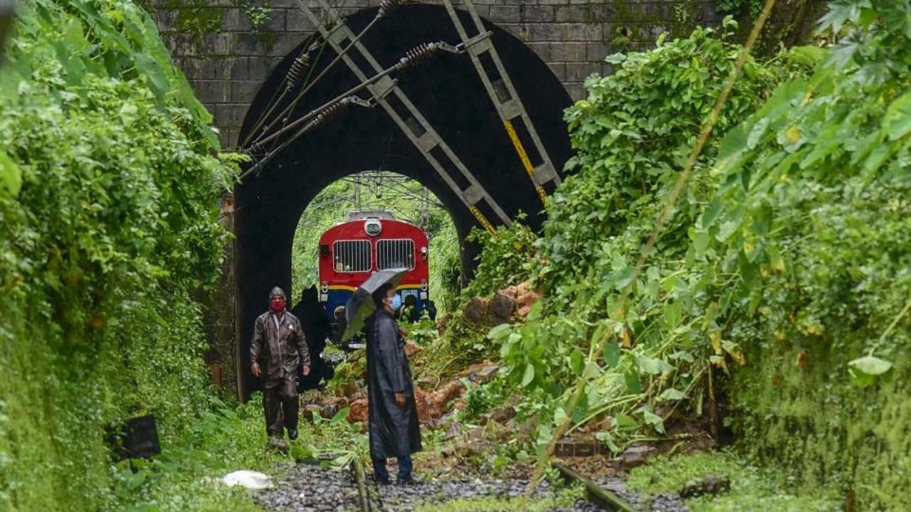 Railway officials inspect a track, damaged due to a landslide following heavy rain, at Muttamplam in Kottayam district. Credit: PTI