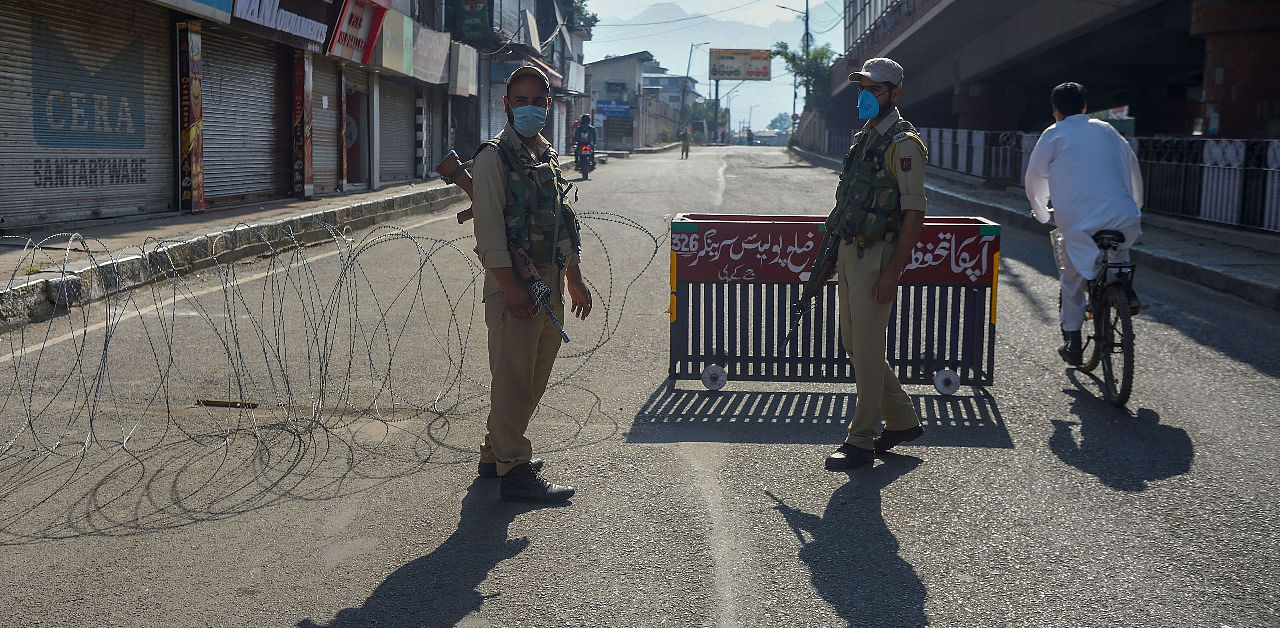 Security personnel stand guard on a street during restrictions imposed in the wake of the first anniversary of Article 370 abrogation, in Srinagar. Credit: PTI Photo