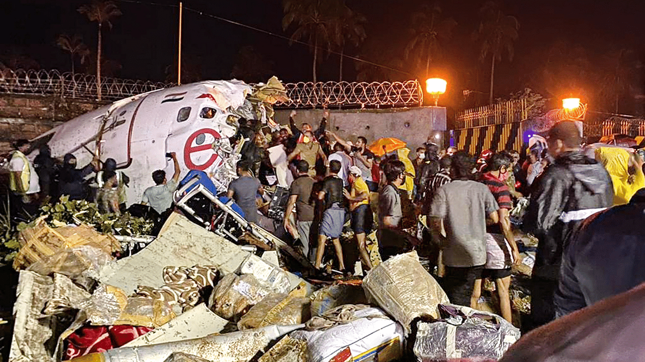 Rescue operation underway after an Air India Express flight with passengers on board en route from Dubai skidded off the runway while landing, at Karippur in Kozhikode. Credits: PTI Photo