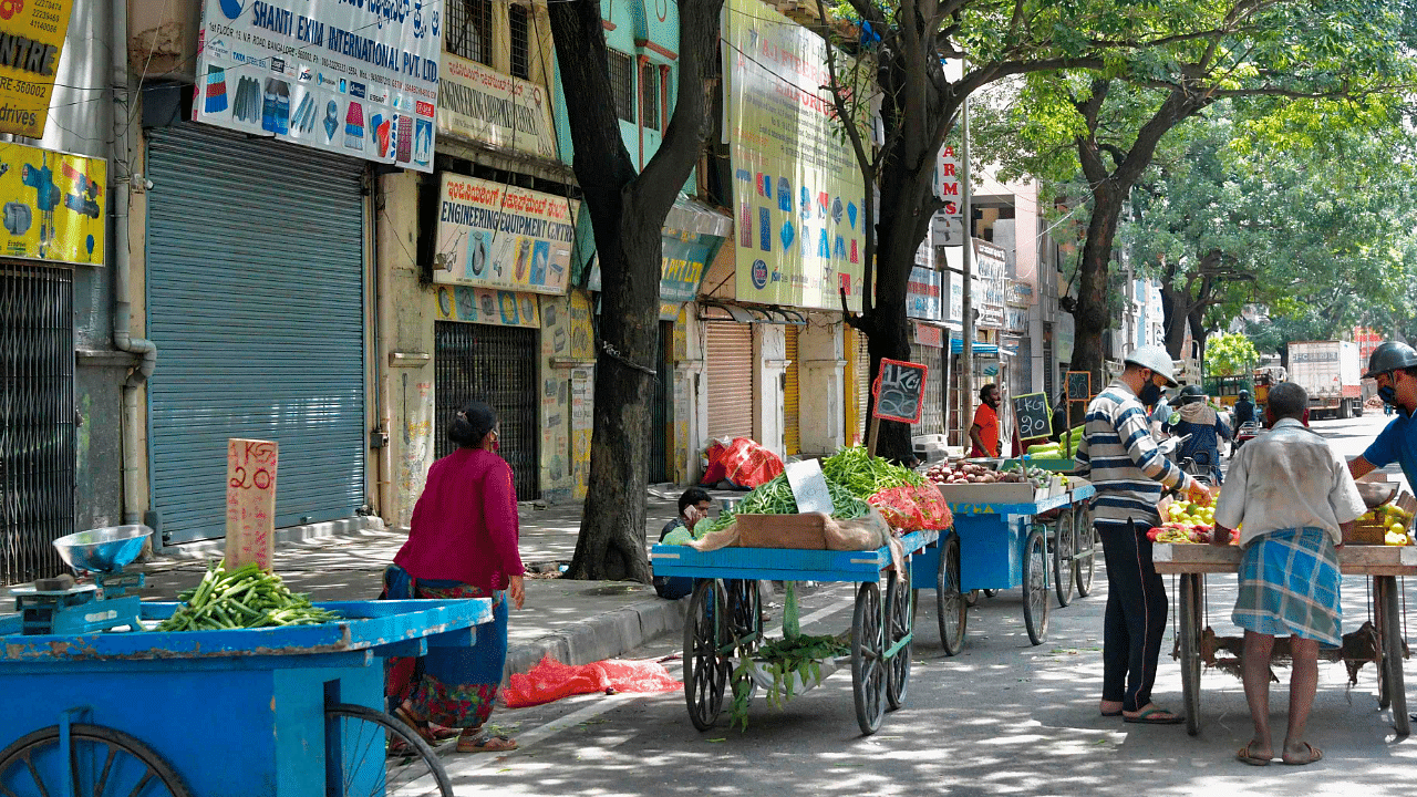 People by vegetables from roadside hawkers. Credits: AFP Photo