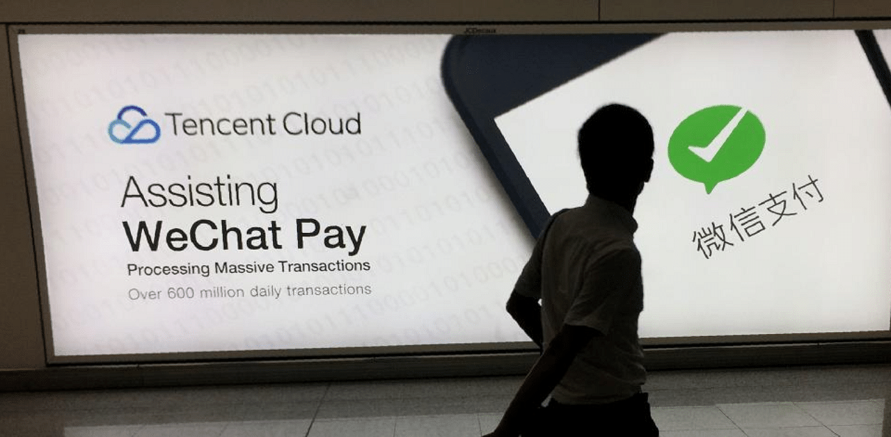 Man walks at Hong Kong's international airport past an advertisement for the WeChat social media platform owned by China's Tencent company. Credit: AFP Photo