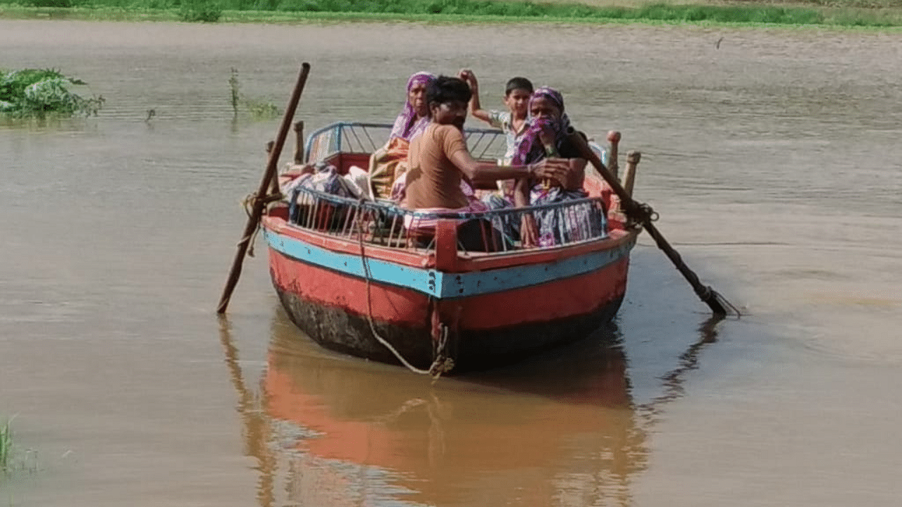 Residents from Yadurwadi village in Chikkodi taluk in Belagavi district residing in the houses in their agricultural lands being shifted to safety by boats with waters of river Krishna marooning the area. Credits: DH Photo