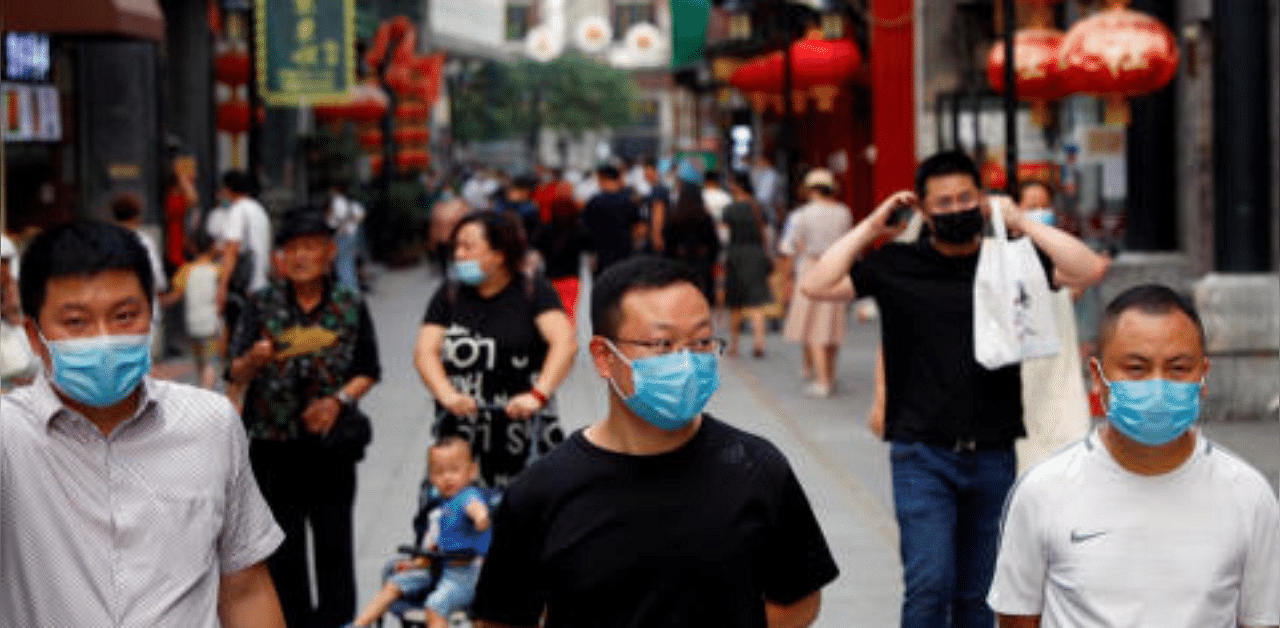People wear protective masks as they walk in a shopping street following the outbreak of the coronavirus disease in China. Credit: Reuters Photo