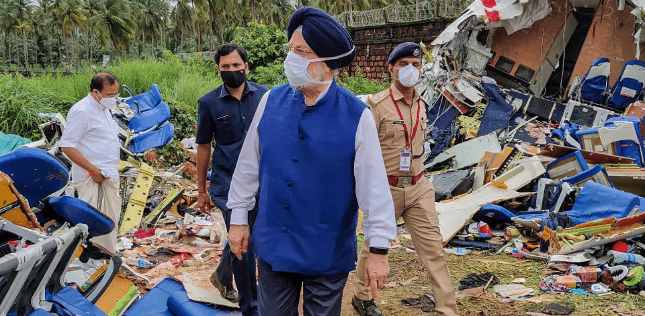 Union Civil Aviation Minister Hardeep Singh Puri inspects the crash site of an Air India Express flight, en route from Dubai, after it skidded off the runway while landing, at Karippur in Kozhikode. Credit: PTI Photo