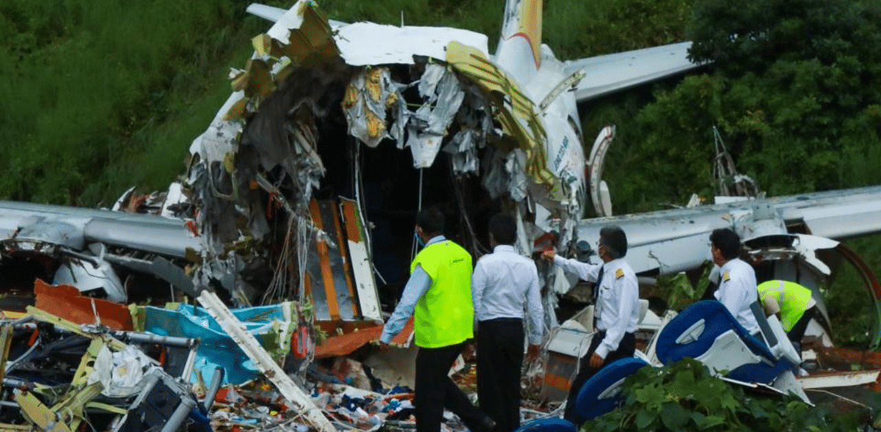 Officials inspect the wreckage of an Air India Express jet at Calicut International Airport. Credit: AFP