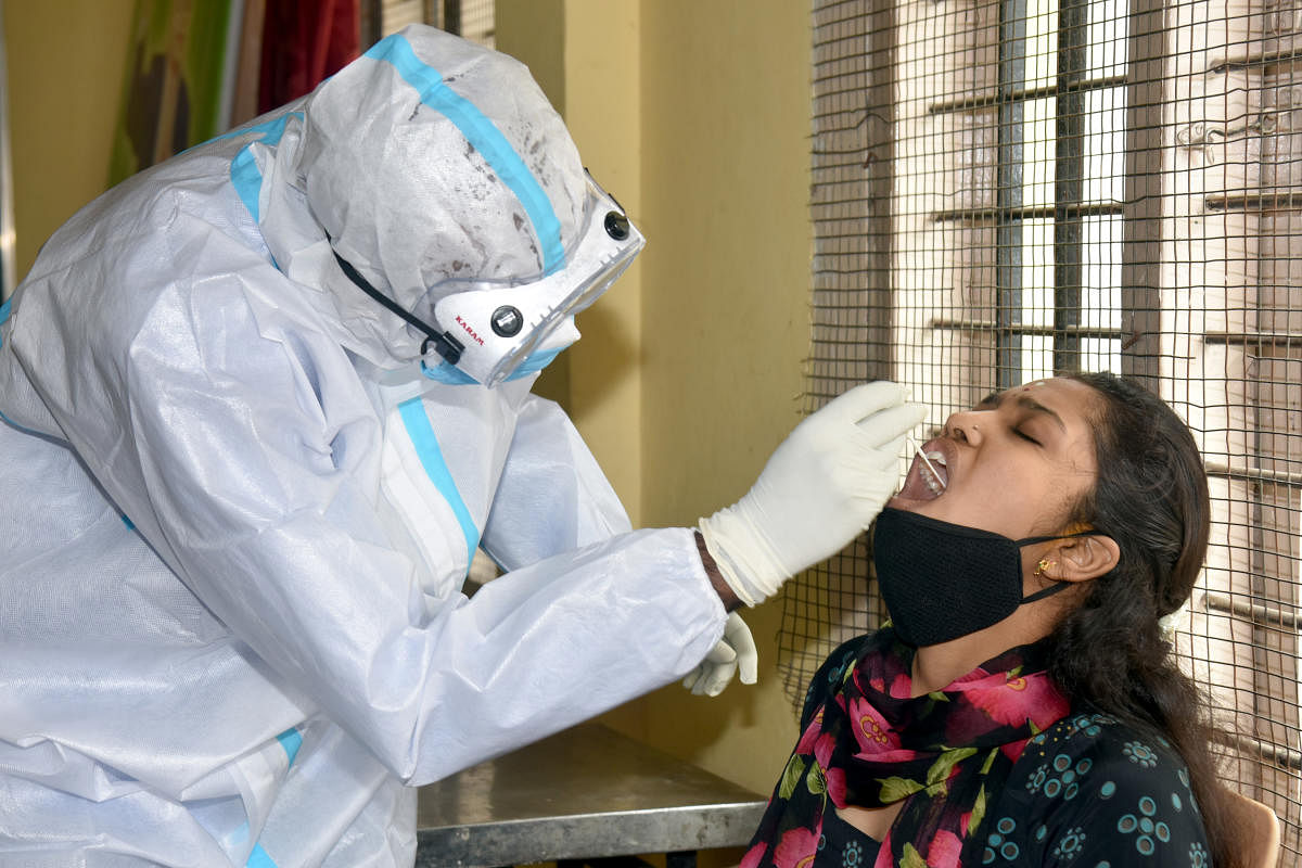 BBMP health staff collecting nasal swab for coronavirus test in Covid 19 lockdown in Maruthi Nagar in Bengaluru on Friday. DH Photo/S K Dinesh