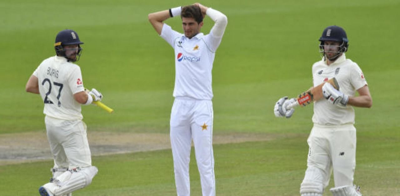 Pakistan's Shaheen Afridi, center, reacts as England's Rory Burns, left, and Dom Sibley run between the wickets to score during the fourth day of the first cricket Test match between England and Pakistan at Old Trafford in Manchester, England, Saturday, Aug. 8, 2020. Credit: AP/PTI Photo