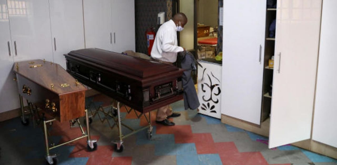 An undertaker of Sopema Funerals changes into his suit before transporting the body of a deceased person ahead of the funeral service, amid a nationwide coronavirus disease. Credit: Reuters