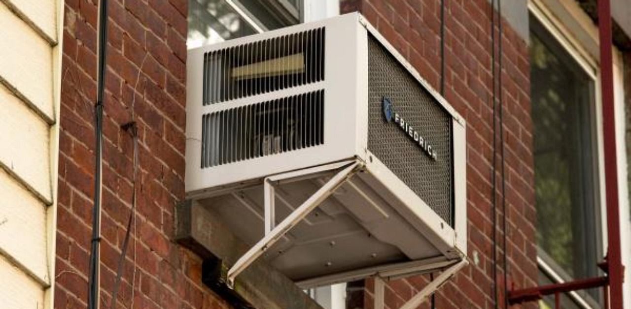 An air conditioner is seen in a residential windows in New York City. Credit: AFP