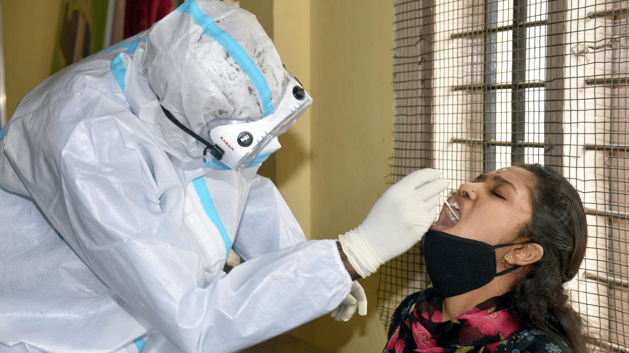 BBMP health staffers collecting nasal swab for Covid-19 testing in Bengaluru. Credits: DH Photo/S K Dinesh