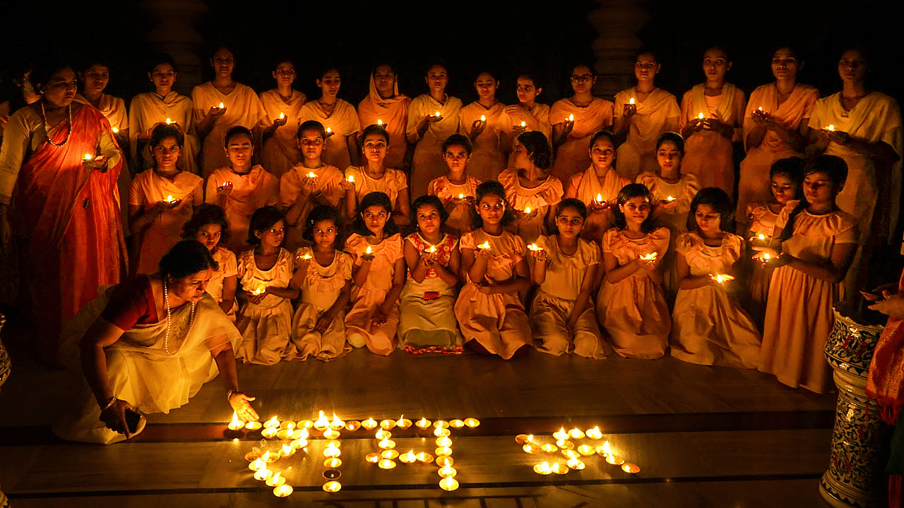 Girls from Panini Kanya Mahavidyalaya light earthen lamps to celebrate the groundbreaking ceremony of the Ayodhya's Ram Temple, in Varanasi. Credits: PTI Photo