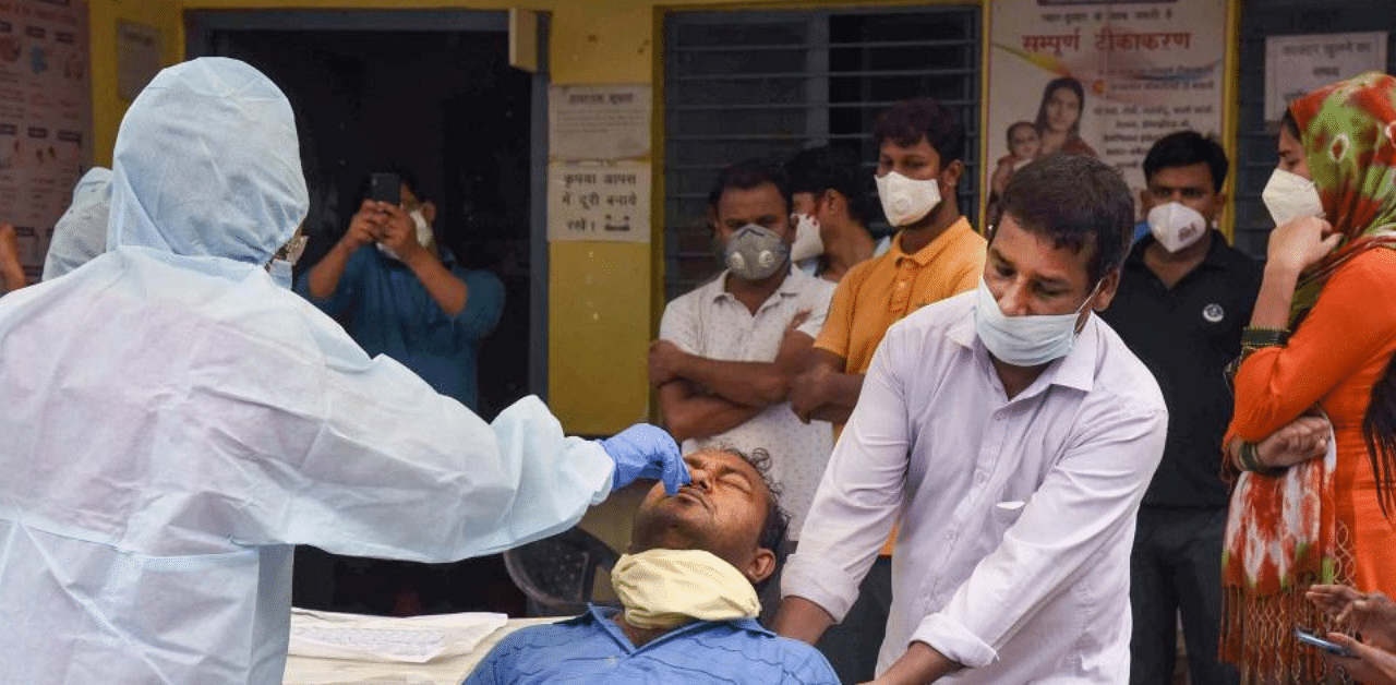A medic takes samples from a man for Covid-19 testing at a camp, during total lockdown, in Patna, Tuesday, July 21, 2020. Credit: PTI Photo