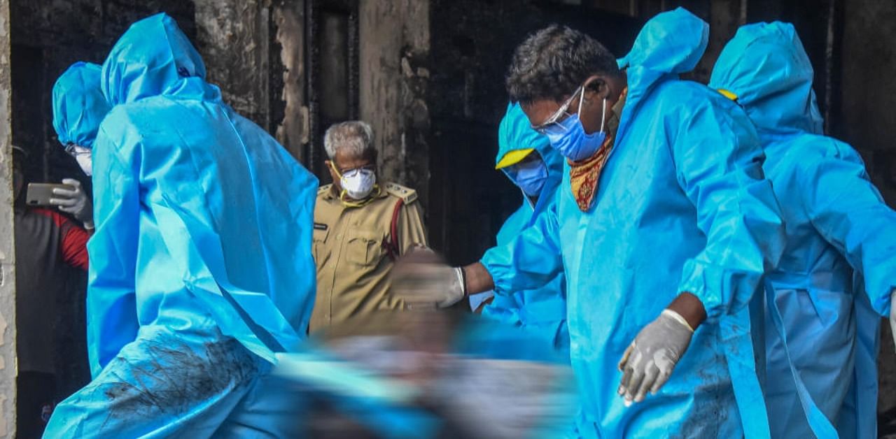 NDRF personnel wearing PPE kits carry out a rescue operation after a massive fire broke out at a hotel, turned into Covid-19 care centre, in Vijayawada, Sunday, Aug. 9, 2020. (PTI)