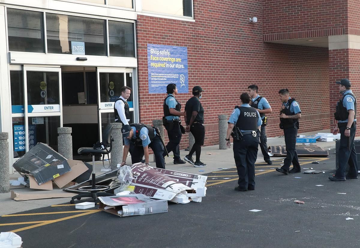  Police officers detain a man who was found inside of a Best Buy store after parts of the city had widespread looting and vandalism, on August 10, 2020 in Chicago, Illinois. Credit: AFP Photo