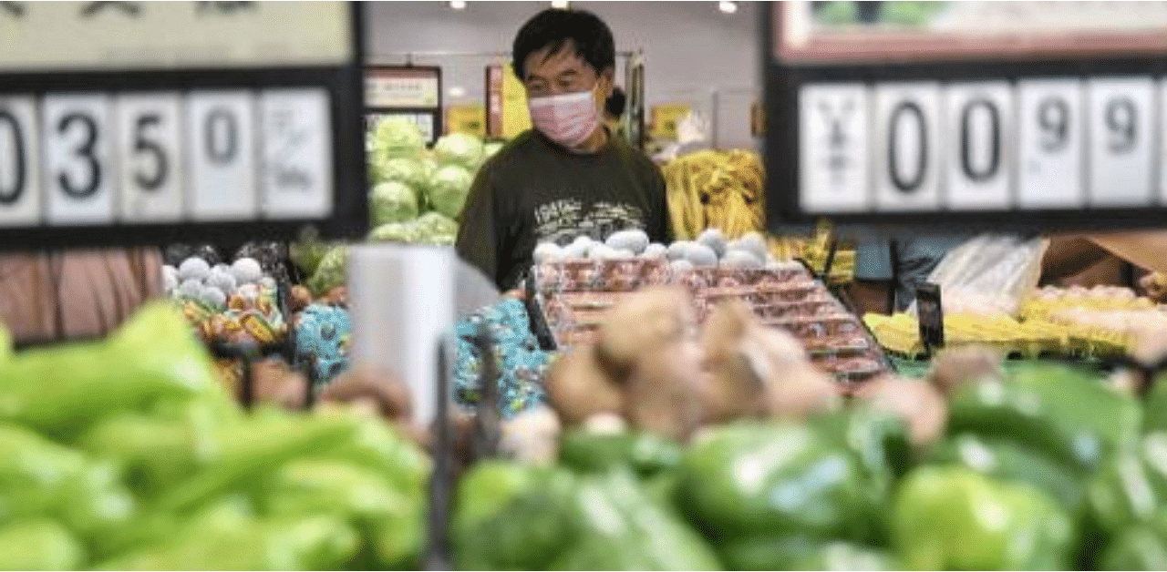 A customer buys vegetables at a supermarket in Handan in China's northern Hebei province. Credit: AFP Photo