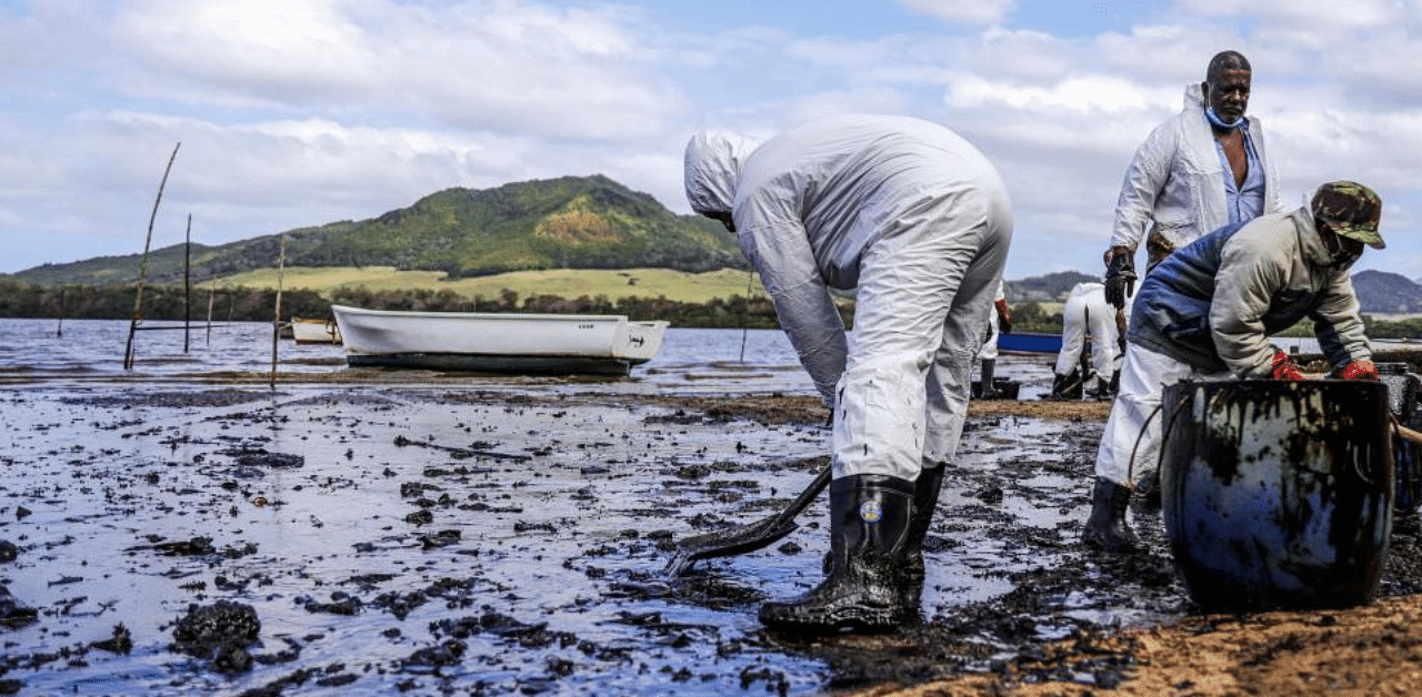 People scoop leaked oil from the vessel MV Wakashio, belonging to a Japanese company but Panamanian-flagged, that ran aground and caused oil leakage near Blue bay Marine Park in southeast Mauritius. Credit: AFP Photo