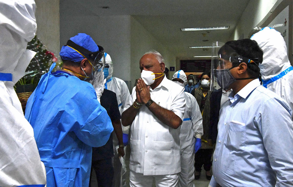 Chief Minister B S Yediyurappa thanks the health staff as he walks out of Manipal Hospital in Bengaluru on Monday. He was under treatment for Covid-19.