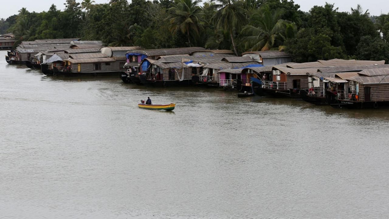 A motorboat moves past a row of empty houseboats in a tributary of the Pamba river following floods in Alappuzha district in the southern state of Kerala. Credit: Reuters/file