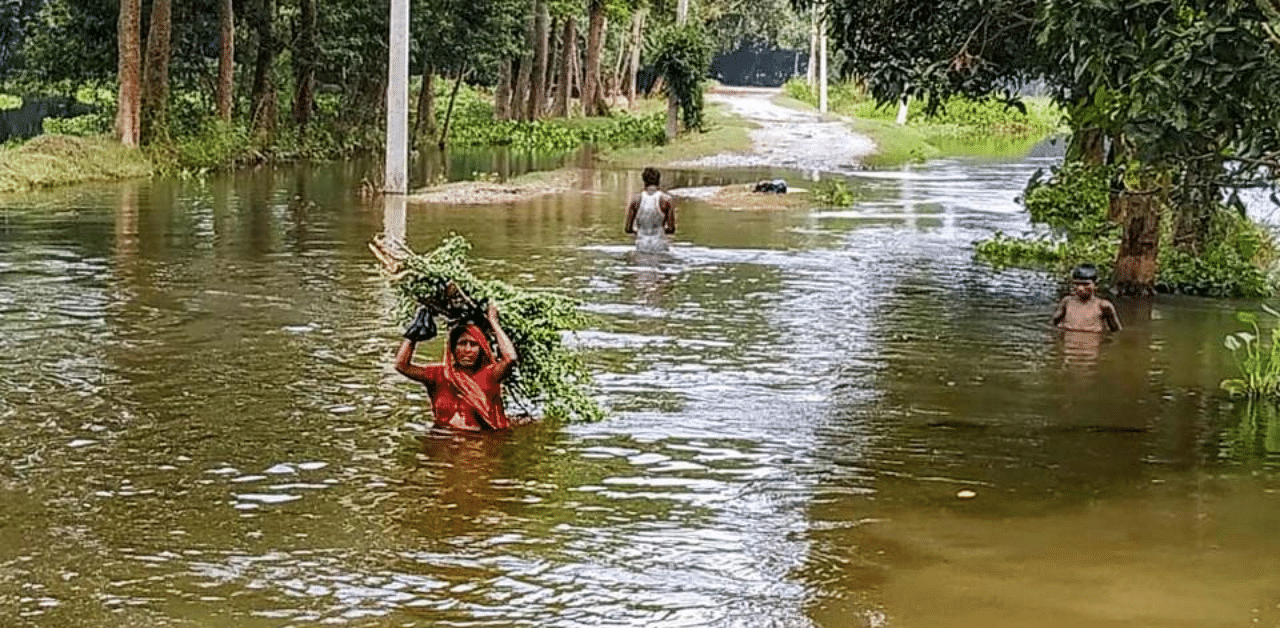  Villagers wade through a flooded area following incessant rain, in Saharsa district, Friday, July 31, 2020. Credit: PTI Photo