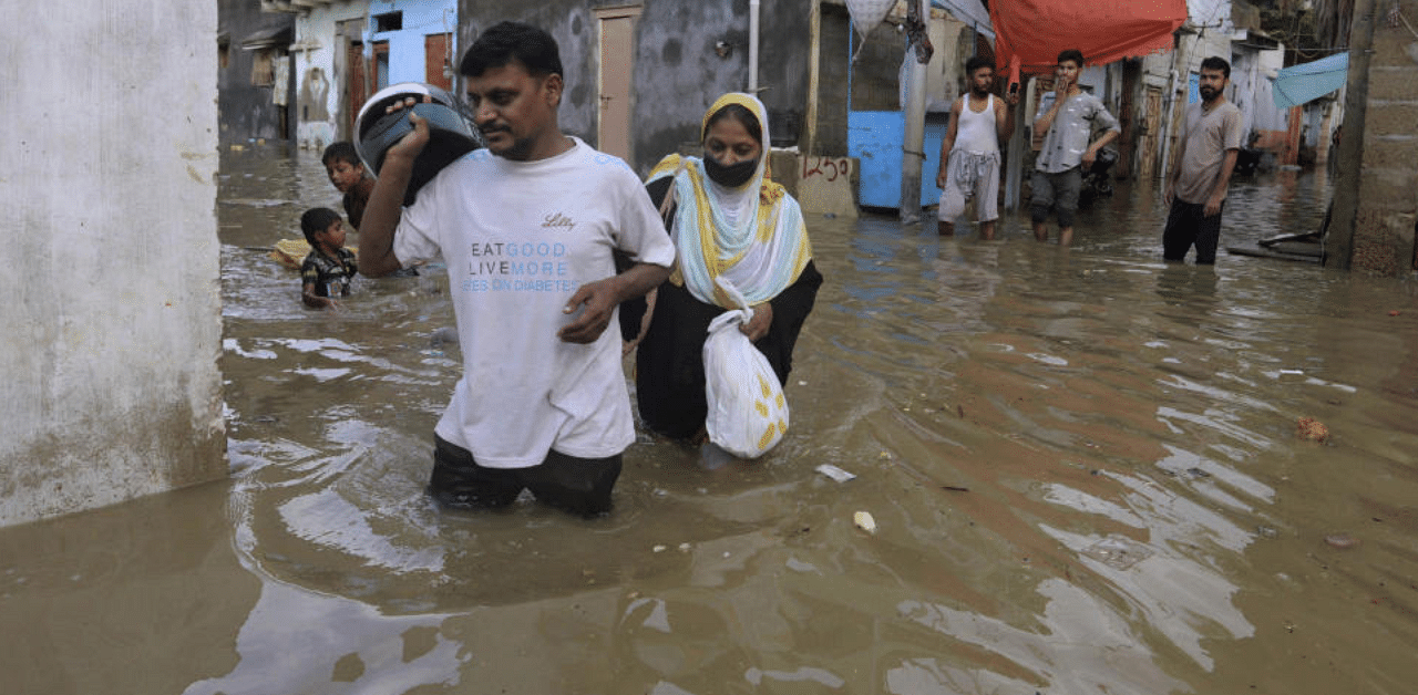  Residents navigate through a flooded street after a heavy rainfall in Karachi, Pakistan. Credit: AP File Photo