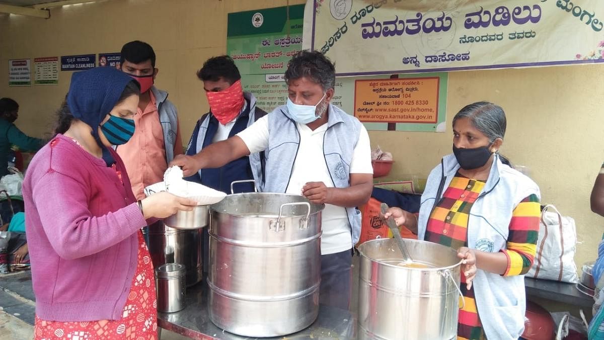 Mangala Yogish and K P Aruna Kumari of Parisara Rural Development Society serve food to pregnant women near the Maternity division of Mandya Institute of Medical Sciences Hospital, under ‘Mamatheya Madilu’ project.