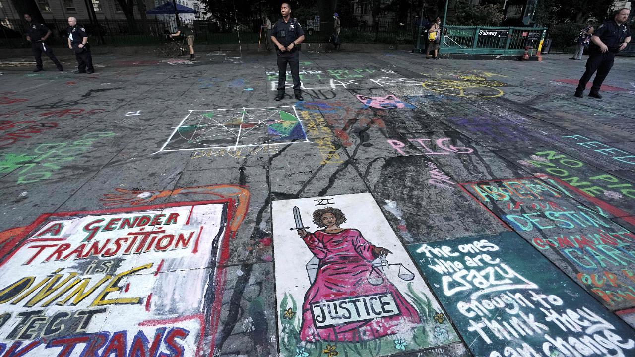 New York police officers standby as sanitation workers remove graffiti at the site of Occupy City Hall protest. Credits: AFP Photo