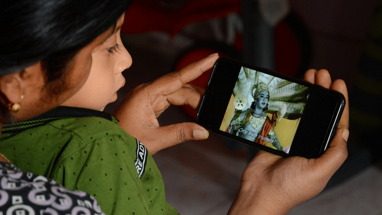 A young girl watches Ramayana in her phone, during a nationwide lockdown, imposed in the wake of coronavirus pandemic. Credits: PTI Photo